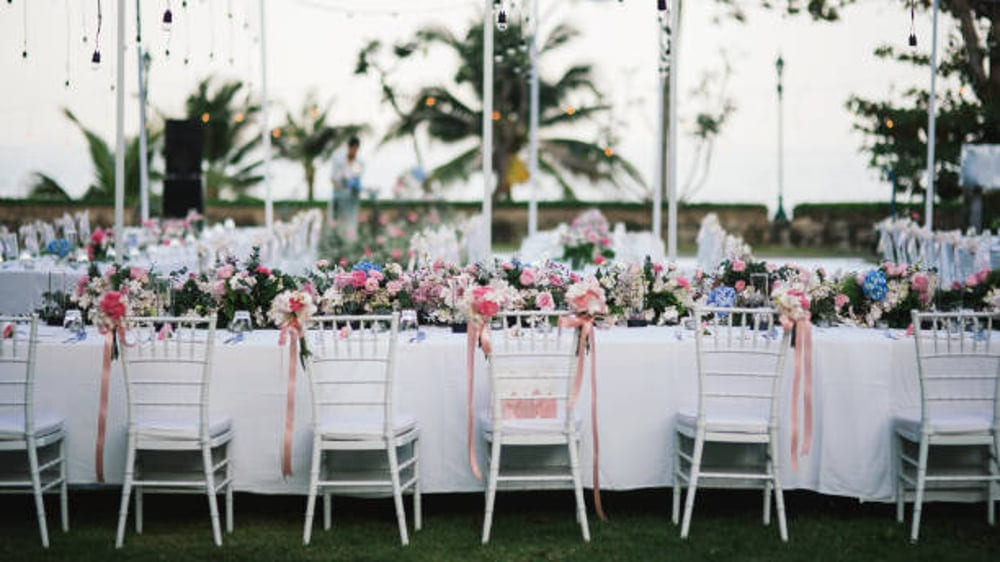 mobiliario para fiestas.Sillas blancas con una mesa, en el jardín 