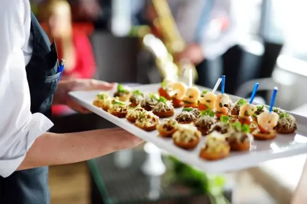comida buffet para eventos.Mesera llevando comida y canapes