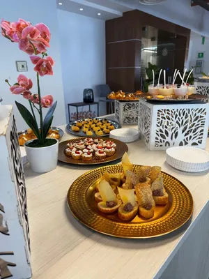 Comida que está servida sobre charolas, hay una mesa decorada con comida para eventos a domicilio