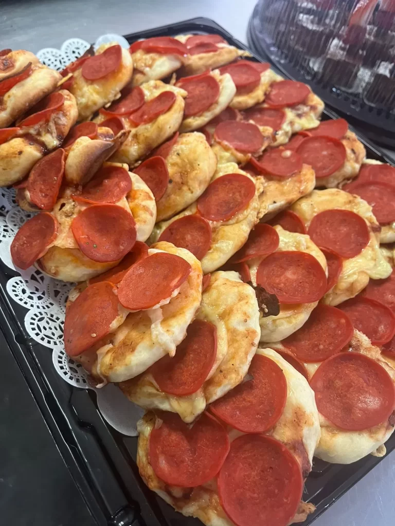 Unas mini pizzas que están listas para ser servidas en un servicio de canapés y bocadillos