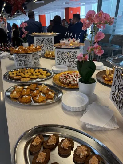 Hay un mantel blanco en una mesa, en esta hay varios platillos con comida y es lo que lleva un banquete