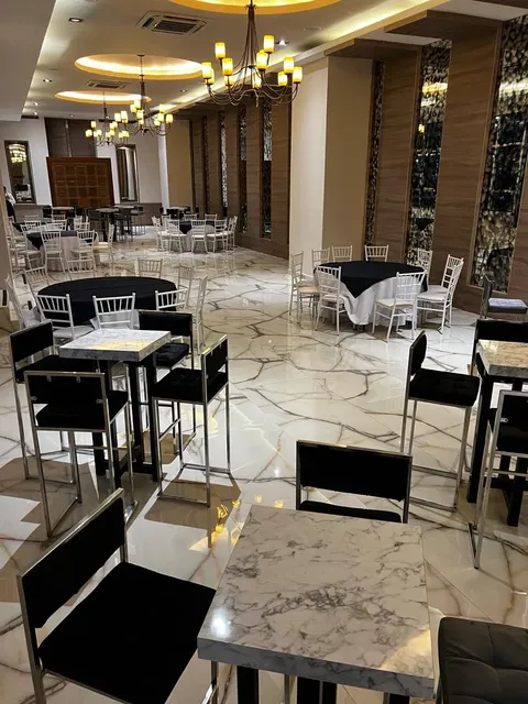 Las mesas y sillas están acomodadas en un salón que está haciendo decoración de banquetes