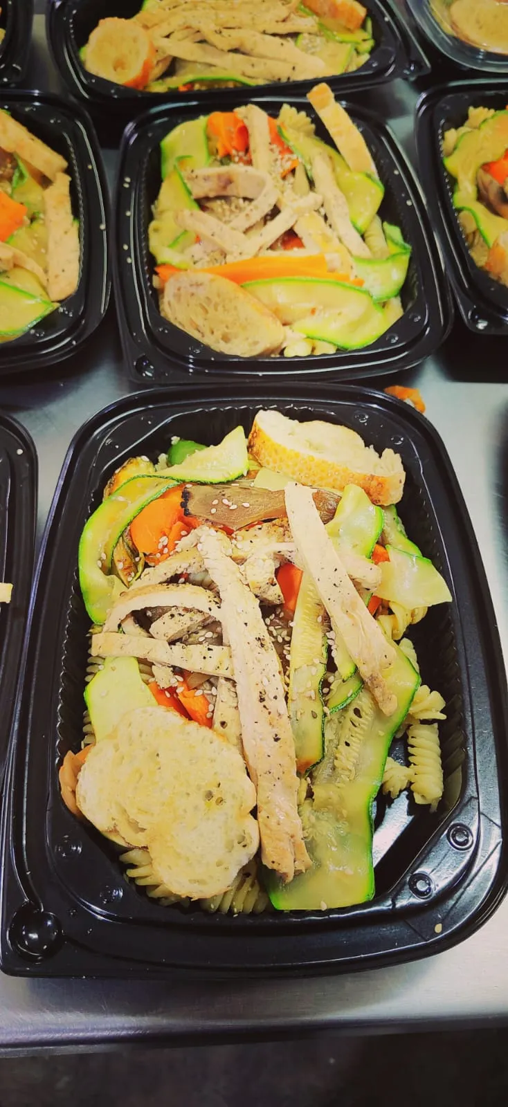 Una vista de primer plano de un saludable box lunch empacado en un recipiente negro, un toque a este práctico box lunch, ideal para una comida equilibrada sobre la marcha.