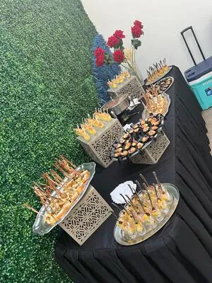 Elegante mesa de presentación con bocados individuales como camarones y shots de aperitivos. Una opción sofisticada para banquetes para fiestas.