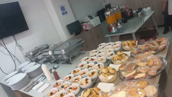 Variedad de frutas frescas y pan artesanal servidos en un banquete para cumpleaños tipo buffet matutino con jugo de naranja.