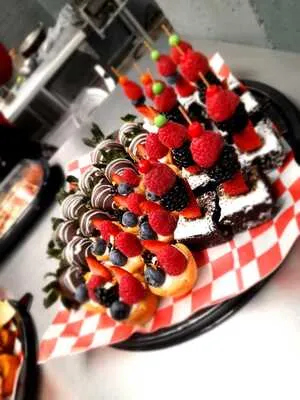 Postres miniatura y brochetas de frutos rojos, parte de las tendencias en banquetes para bodas enfocadas en el detalle.
