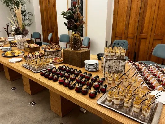 Elegante mesa de postres y canapés individuales para banquetes para bodas en primavera con decoración de flores.