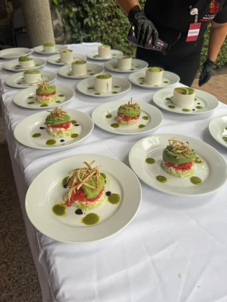 Presentación de torre de camarón y aguacate para evitar errores al contratar un servicio de catering de alta calidad.