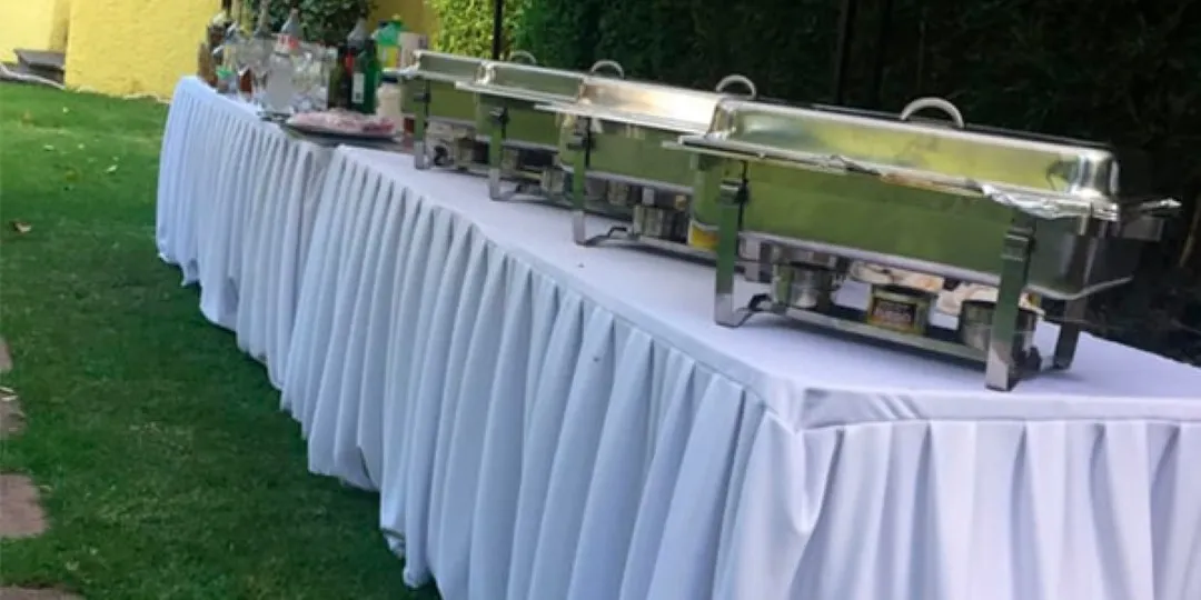 Montaje de buffet caliente al aire libre para banquetes para eventos sociales y corporativos en jardines elegantes.