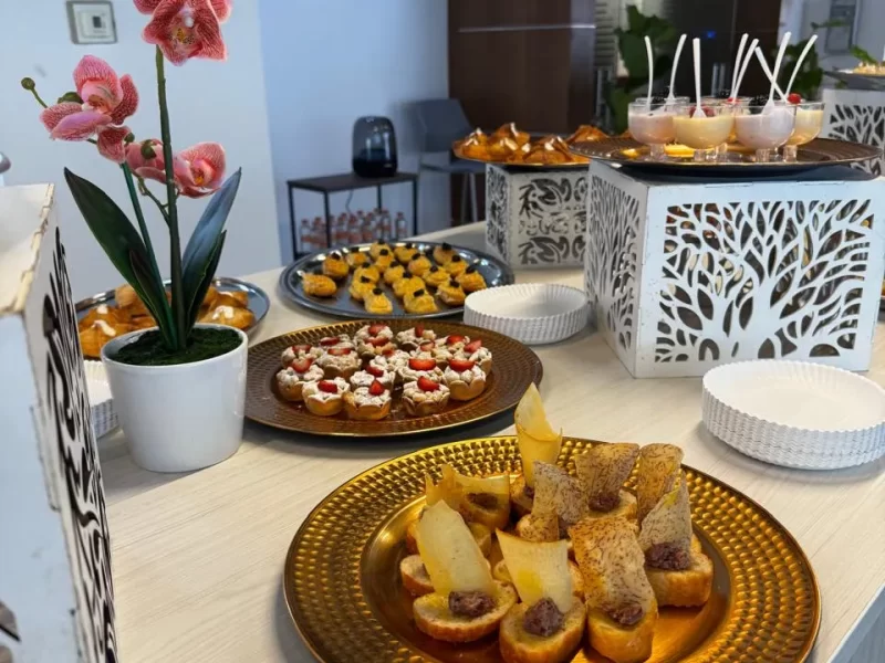 Banquetes para eventos empresariales, se muestran bandejas llenas de comida y postres, sobre una mesa