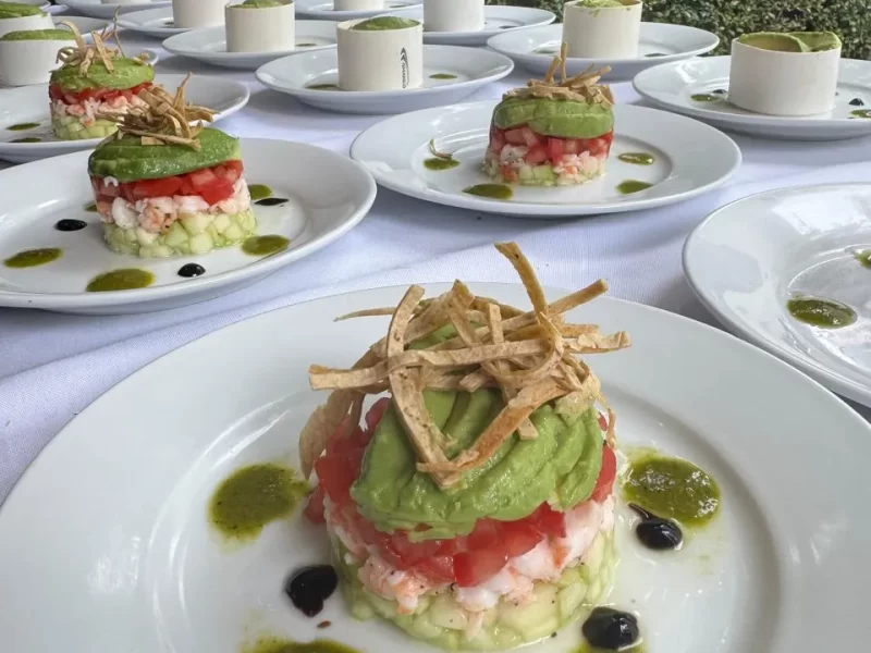 Sobre una mesa con un mantel blanco hay varios platos de comida, es saber cuantos platillos se necesitan para un evento